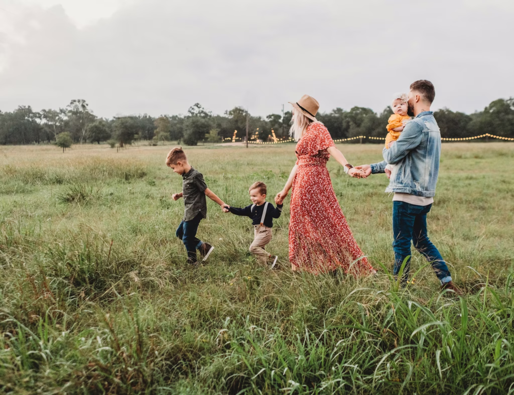 Family all together holding hands on open land